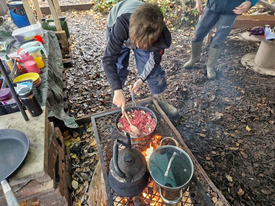 Outdoor camp cooking setup using portable stove and kettle